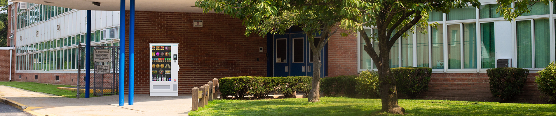 Ein Automat neben einer Grünfläche an einem Gebäude