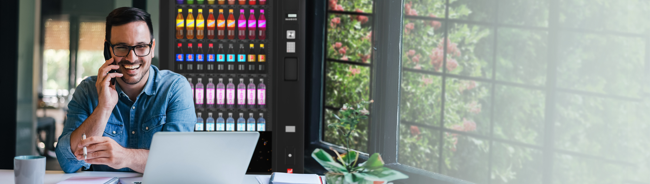 Ein Mann der vor einem Automaten am Laptop Arbeitet