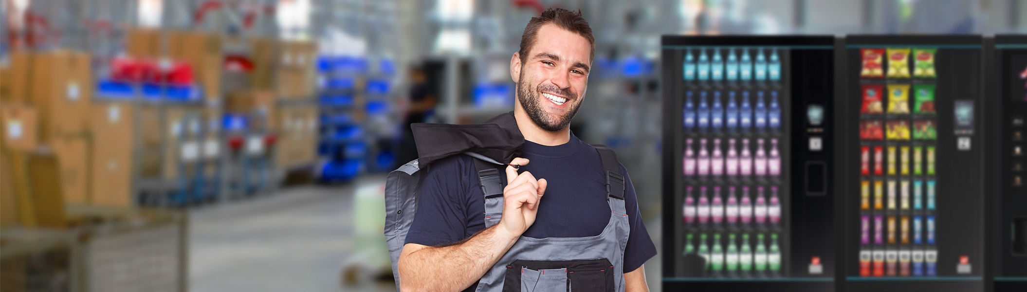 Ein Mann in Arbeitsklamotten vor drei Automaten